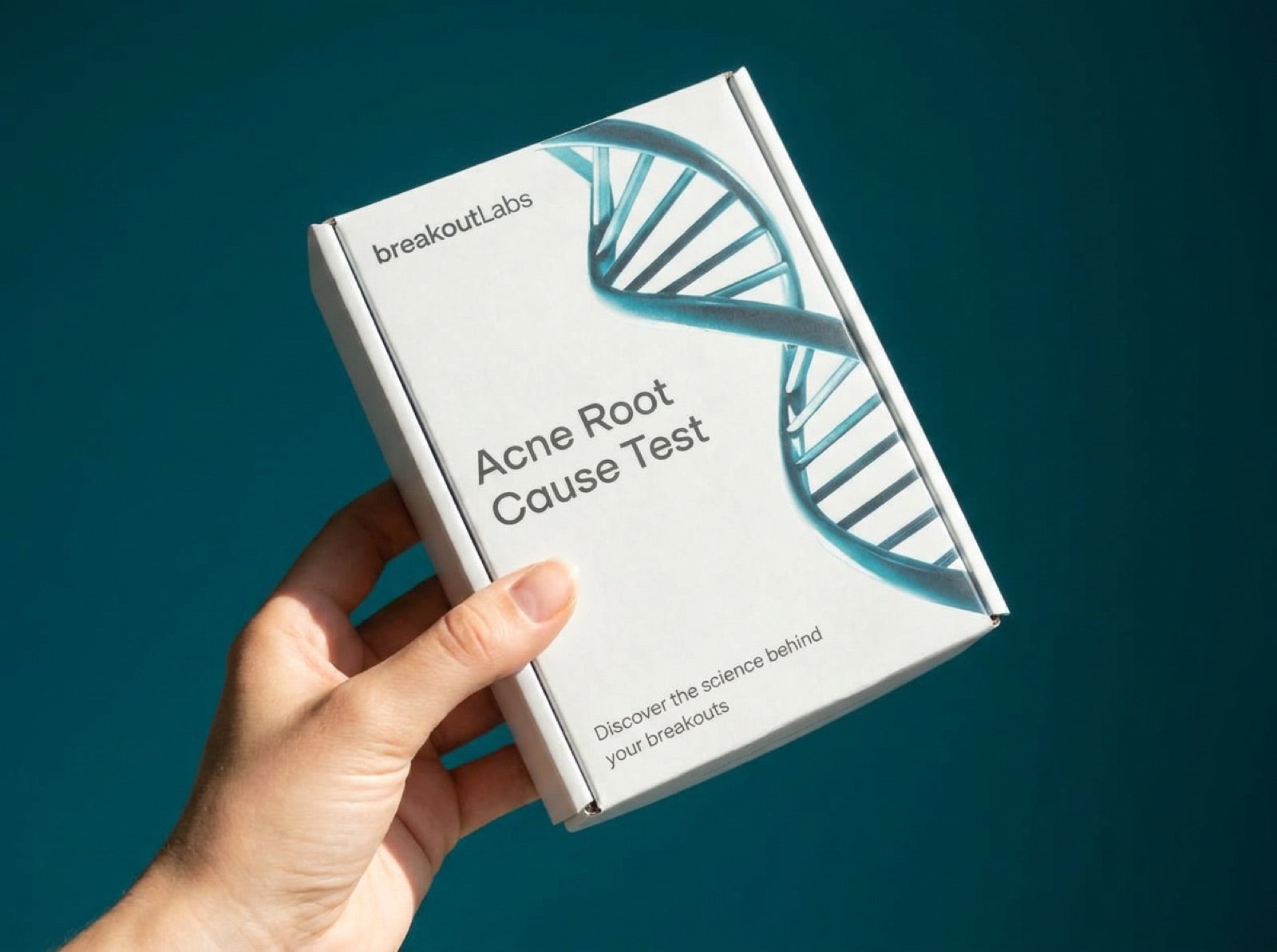 Hand holding the breakoutLabs Acne Root Cause Test kit box